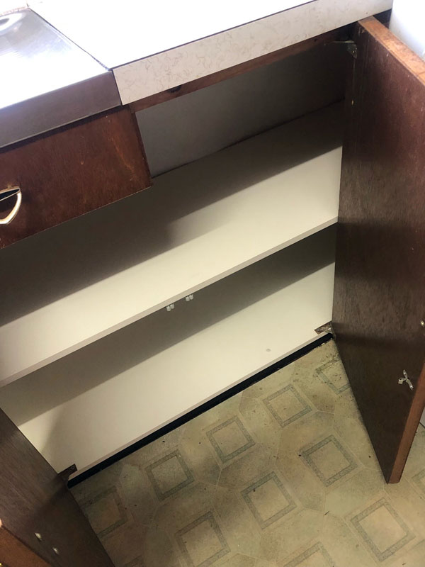 Open timber cupboard with clean white shelves inside